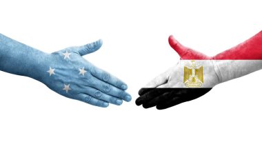 Mikronezya ve Mısır bayrakları arasındaki el sıkışma ellerinde izole edilmiş şeffaf görüntü.