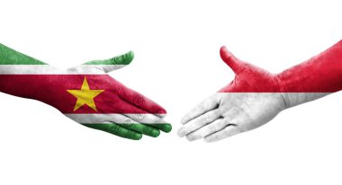 Ellere boyanmış Monako ve Surinam bayrakları arasındaki el sıkışma, izole şeffaf görüntü.