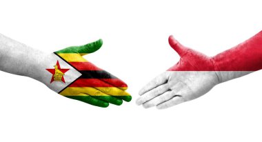 Monaco ve Zimbabwe bayrakları arasındaki el sıkışma ellerinde izole şeffaf görüntü.