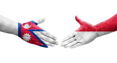 Ellere boyanmış Monako ve Nepal bayrakları arasındaki el sıkışma, izole saydam görüntü.