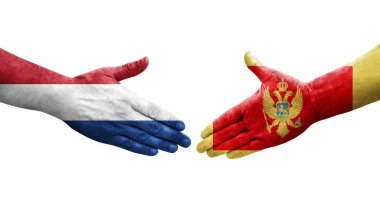 Karadağ ile Hollanda arasındaki el sıkışma, elde boyanmış bayraklar ve izole edilmiş şeffaf görüntü.