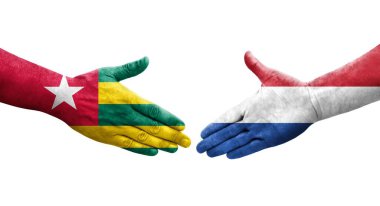 Hollanda ve Togo bayrakları arasındaki el sıkışma ellerinde resmedilmiş şeffaf görüntü.