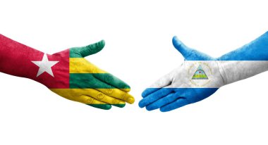 Nikaragua ve Togo bayrakları arasındaki el sıkışma ellerinde izole şeffaf görüntü.