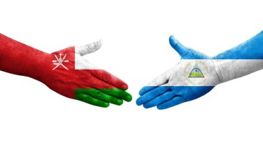 Nikaragua ve Umman bayrakları arasındaki el sıkışma ellerinde izole şeffaf görüntü.
