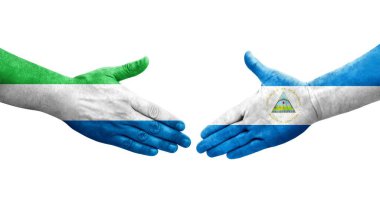 Nikaragua ve Sierra Leone bayrakları arasındaki el sıkışma ellerinde izole şeffaf görüntü.