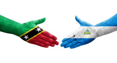 Nikaragua ve Saint Kitts ve Nevis bayrakları arasındaki el sıkışma, izole şeffaf görüntü.