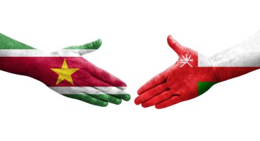 Umman ve Surinam bayrakları arasındaki tokalaşma elleri boyalı, izole şeffaf görüntü.