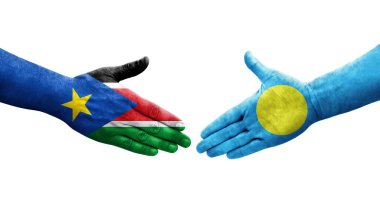 Palau ve Güney Sudan bayrakları arasındaki el sıkışma ellerinde resmedilmiş şeffaf görüntü.