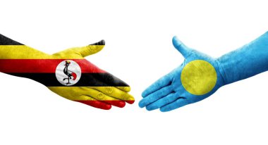Palau ve Uganda bayrakları arasındaki tokalaşma elleri boyalı, izole şeffaf görüntü.