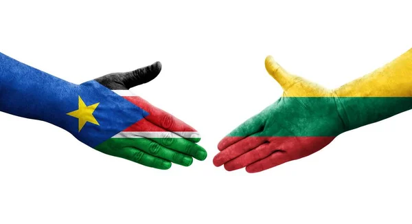 Stock image Handshake between Lithuania and South Sudan flags painted on hands, isolated transparent image.