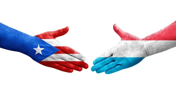 stock image Handshake between Luxembourg and Puerto Rico flags painted on hands, isolated transparent image.