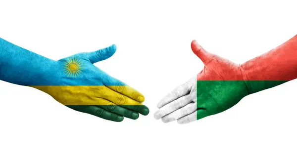 stock image Handshake between Madagascar and Rwanda flags painted on hands, isolated transparent image.