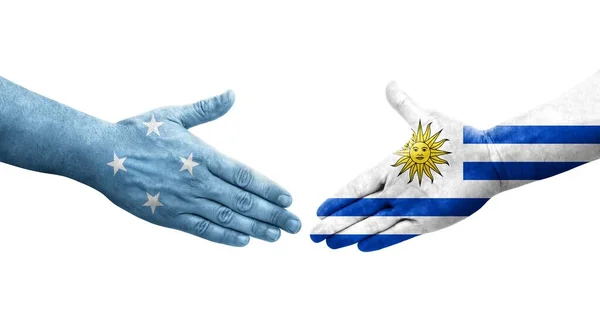 密克罗尼西亚和乌拉圭国旗之间的握手手绘 孤立透明的图像 — 图库照片