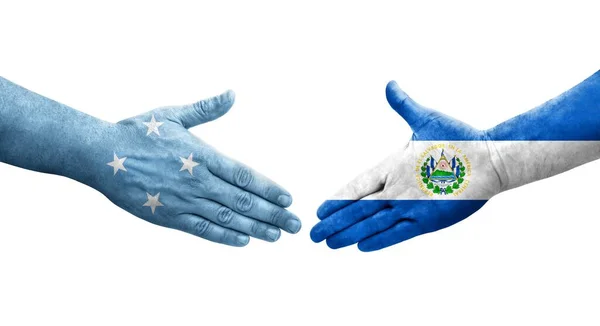 stock image Handshake between Micronesia and El Salvador flags painted on hands, isolated transparent image.