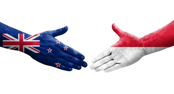 stock image Handshake between Monaco and New Zealand flags painted on hands, isolated transparent image.