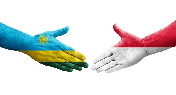 Stock image Handshake between Monaco and Rwanda flags painted on hands, isolated transparent image.