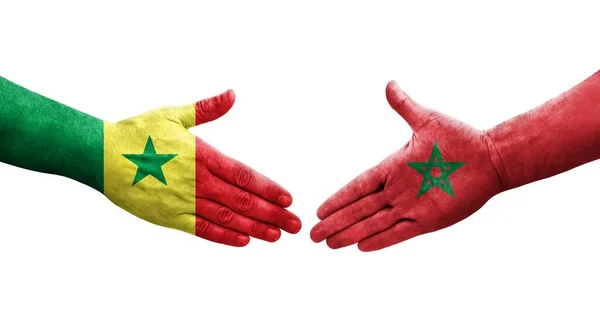 stock image Handshake between Morocco and Senegal flags painted on hands, isolated transparent image.