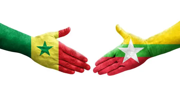 Stock image Handshake between Myanmar and Senegal flags painted on hands, isolated transparent image.