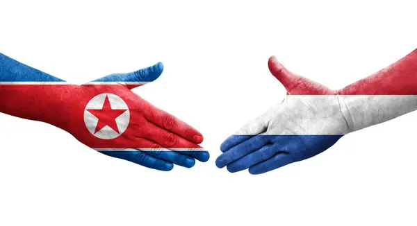 Händedruck Zwischen Niederländischen Und Nordkoreanischen Flaggen Auf Hände Gemalt Isoliertes — Stockfoto