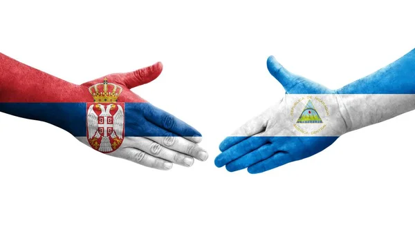 니카라과와 세르비아의 국기가 손으로 그려지는 가운데 분리되어 이미지가 반짝이고 — 스톡 사진