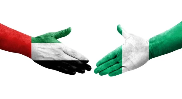 手に描かれたナイジェリアとUaeの旗の間の握手 隔離された透明画像 — ストック写真