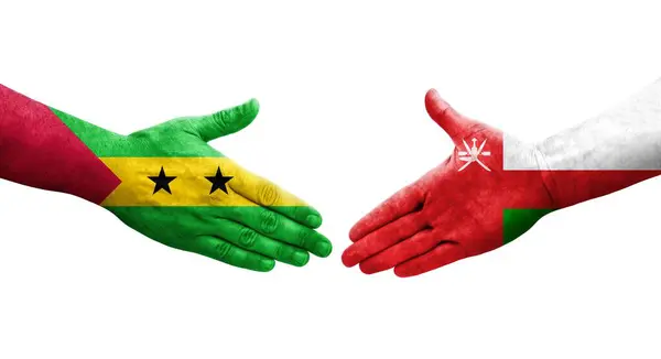 stock image Handshake between Oman and Sao Tome and Principe flags painted on hands, isolated transparent image.