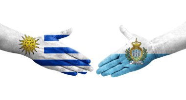 San Marino ve Uruguay bayrakları arasındaki el sıkışma, izole şeffaf görüntü.