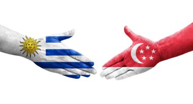 Singapur ve Uruguay bayrakları arasındaki tokalaşma elleri boyalı, izole şeffaf görüntü.