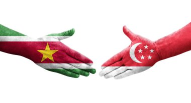 Singapur ve Surinam bayrakları arasındaki tokalaşma elleri boyalı, izole şeffaf görüntü.
