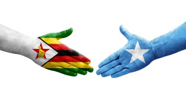 Somali ve Zimbabwe bayrakları arasındaki el sıkışma ellerinde izole şeffaf görüntü.