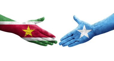 Somali ve Surinam bayrakları arasındaki el sıkışma ellerinde izole şeffaf görüntü.