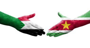 Sudan ve Surinam bayrakları arasındaki tokalaşma elleri boyalı, izole saydam görüntü.