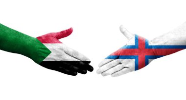 Sudan ve Faroe Adaları arasındaki el sıkışma ellerinde boyanmış bayraklar, izole şeffaf görüntü.