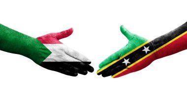 Sudan ve Saint Kitts ve Nevis bayrakları arasındaki el sıkışma ellerinde izole şeffaf görüntü.