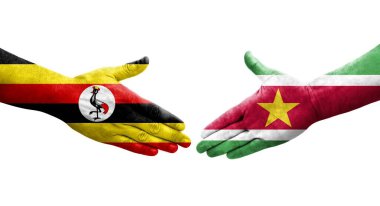 Surinam ve Uganda bayrakları arasındaki el sıkışma ellerinde izole şeffaf görüntü.