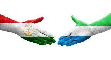 Tacikistan ve Sierra Leone bayrakları arasındaki tokalaşma ellerinde izole şeffaf görüntü.