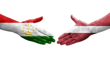 Tacikistan ve Letonya bayrakları arasındaki el sıkışma, izole şeffaf görüntü.