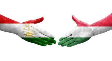Ellerine Tacikistan ve Macaristan bayrakları arasında el sıkışma, izole şeffaf görüntü.