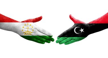 Ellerine Tacikistan ve Libya bayrakları arasında el sıkışma, izole şeffaf görüntü.