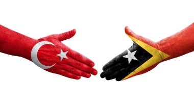 Ellere boyanmış Timor Leste ve Türkiye bayrakları arasındaki el sıkışma, izole şeffaf görüntü.
