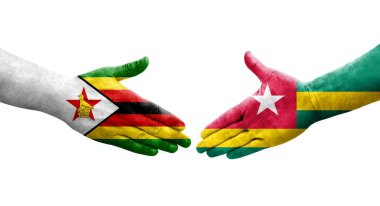 Togo ve Zimbabwe bayrakları arasındaki tokalaşma elleri boyalı, izole şeffaf görüntü.