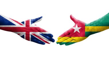 Togo ve Birleşik Krallık bayrakları arasındaki tokalaşma elleri boyalı, izole şeffaf görüntü.