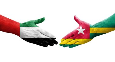 Togo ve BAE bayrakları arasındaki tokalaşma elleri boyalı, izole şeffaf görüntü.