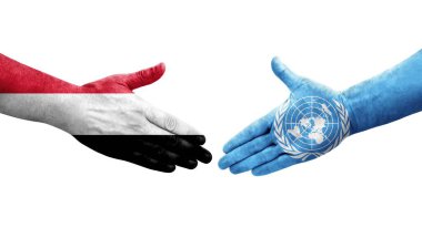 Birleşmiş Milletler ve Yemen bayrakları arasındaki el sıkışma ellerinde resmedilmiş şeffaf görüntü.