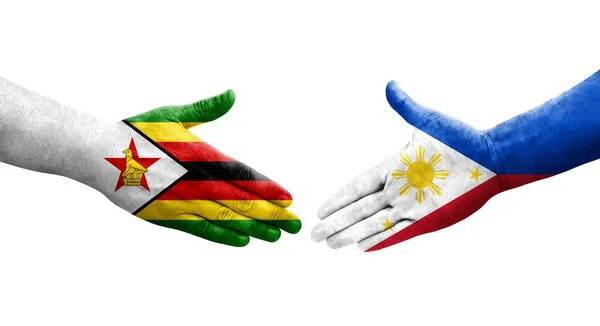 手に描かれたフィリピンとジンバブエの旗の間の握手 隔離された透明なイメージ — ストック写真