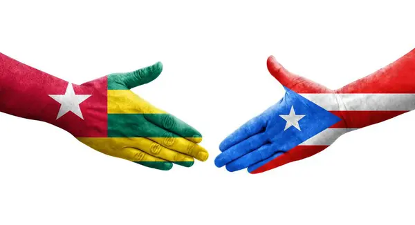 Stock image Handshake between Puerto Rico and Togo flags painted on hands, isolated transparent image.