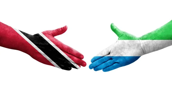 stock image Handshake between Sierra Leone and Trinidad Tobago flags painted on hands, isolated transparent image.