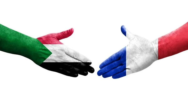 手に描かれたスーダンとフランスの旗の間の握手 隔離された透明なイメージ — ストック写真