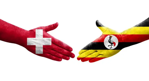 stock image Handshake between Switzerland and Uganda flags painted on hands, isolated transparent image.