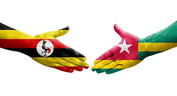 Togo Uganda Bayrakları Arasındaki Tokalaşma Elleri Boyalı Izole Şeffaf Görüntü — Stok fotoğraf